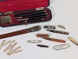 de nombreux types de stylos et de couteaux dans un étui