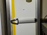 un réfrigérateur qui se trouve dans le coin d'une pièce