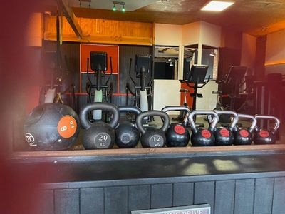 many kettle weights sitting on a table in a gym