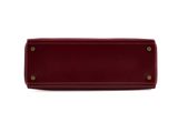 a red leather purse with brass hardware on a white background