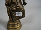 a bronze statue of a woman sitting on a chair