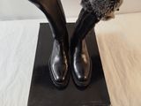 pair of black leather boots with fur cuffs on a black box
