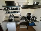 a small kitchen with a sink, stove, dishwasher, and other appliances