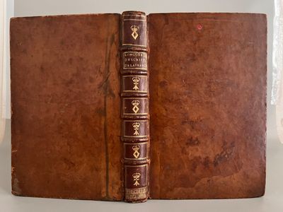 un vieux livre à la couverture brune posé sur une table