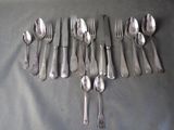 a lot of silver spoons and forks laid out on a table