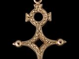 un pendentif en forme de croix en or, orné d'un motif celtique sur fond noir
