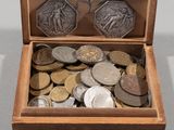 a wooden box filled with coins on a table