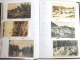 an open book with pictures of a river and a town in it