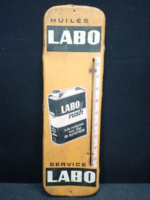 un vieux panneau jaune sur lequel figure un thermomètre et l'inscription « labo »