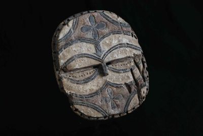 une image représentant un masque sculpté sur fond noir
