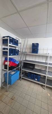 a room that has a bunch of shelves and bins in it