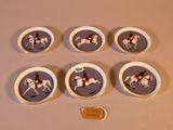 six assiettes en porcelaine ornées de chevaux et de jockeys, posées sur une table