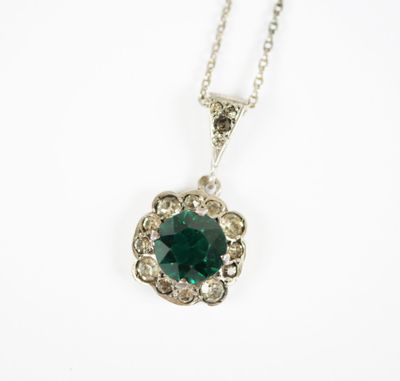 Gros plan sur un collier orné d'une pierre verte