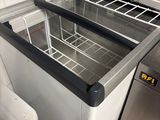a sink with a metal counter top and a metal trash can