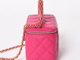 pink quilted purse with gold chain strap on white background