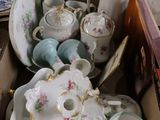 une boîte remplie de tasses à thé et de soucoupes posée sur une table