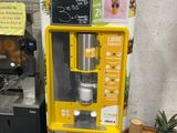 a yellow vending machine with a sign on the side of it