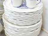 a stack of plates and cups sitting on a table
