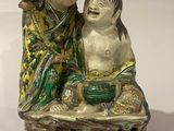 deux figurines représentant un garçon et une fille assis sur un rocher