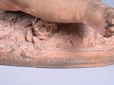a bronze statue of a person holding a flower
