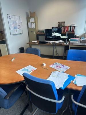une table sur laquelle sont posés plusieurs papiers, dans une pièce