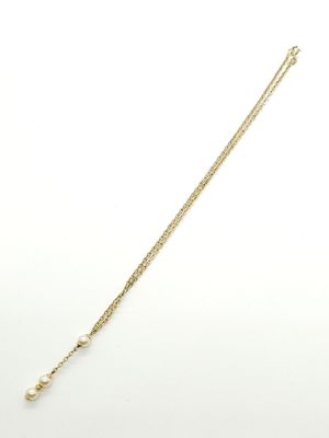 un collier à chaîne en or orné de perles sur fond blanc