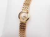 une photo d'une montre-bracelet pour femme posée sur un oreiller