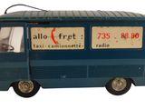 un petit bus en plastique posé sur une surface blanche