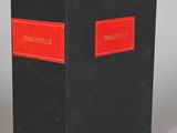 a black and red book with a red label on it