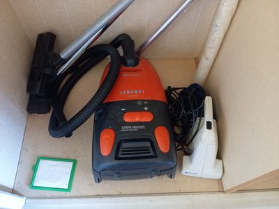 un aspirateur orange et noir posé à l'intérieur d'un carton