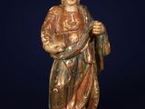 une statue en bois représentant un homme tenant un bâton