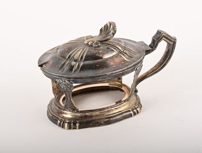 une théière en argent avec un couvercle, posée sur une surface blanche