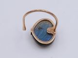 a close up of a gold ring with a blue stone on it