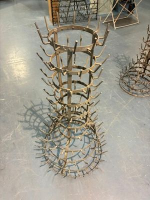 a metal sculpture of a wine rack on the floor