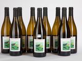 six bouteilles de vin sont alignées sur une surface blanche