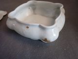 a small white bowl sitting on a table next to a spoon