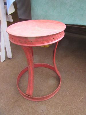 a small red table with a wooden top on the floor