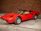 an image of a red sports car parked in front of a brick wall