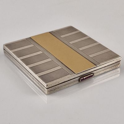 un étui à cigarettes ancien en argent, orné d'une bande dorée sur le devant