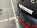 a sticker on the back of a car that is parked on the side of the road