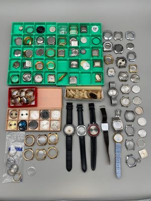 de nombreuses montres de toutes sortes, ainsi que des montres rangées dans une boîte posée sur une table