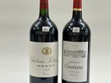two bottles of red wine sitting next to each other on a table