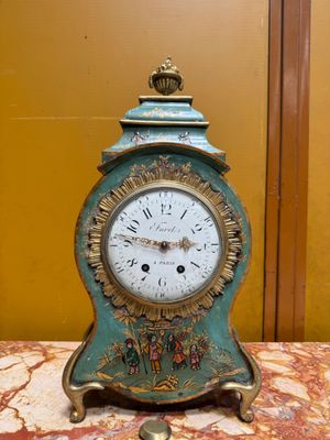 a clock that is sitting on a table in front of a wall