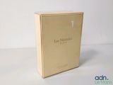 une photo d'un coffret de parfum posé sur une table blanche