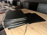 a stack of black folders sitting on a wooden table