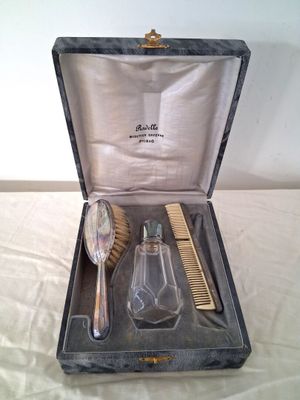 une boîte contenant une brosse, un peigne et un flacon