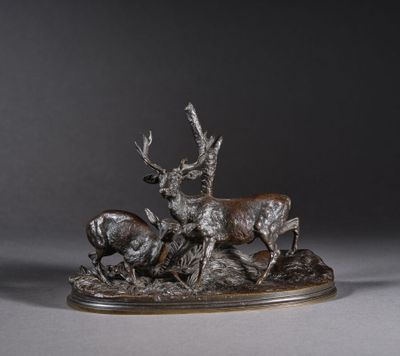 une sculpture en bronze représentant un cerf et deux antilopes posés sur un rocher