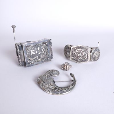 three pieces of silver jewelry sitting on top of a white surface