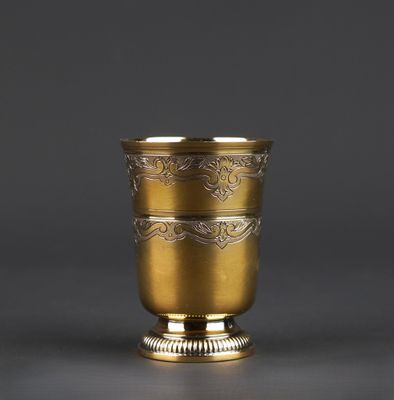 a gold cup with a decorative design on the rim
