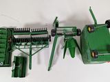 a green toy tractor and a green machine on a white surface